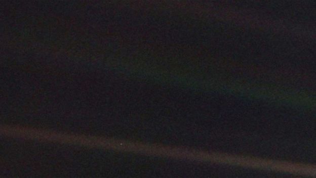 Uma foto escura, em que não se vê nada? Olhe novamente com atenção. O minúsculo pontinho claro é a Terra, a seis bilhões de quilômetros, onde estava a sonda Voyager em 1990. A faixa mais clara sobre o fundo escuro é um raio de luz dispersada. 